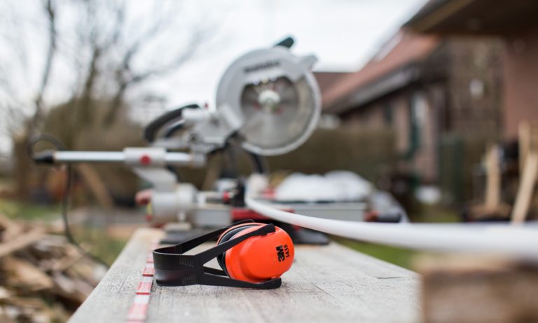 ear-muffs-sitting-by-a-saw-by-an-edmonton-home-that-is-being-renovated