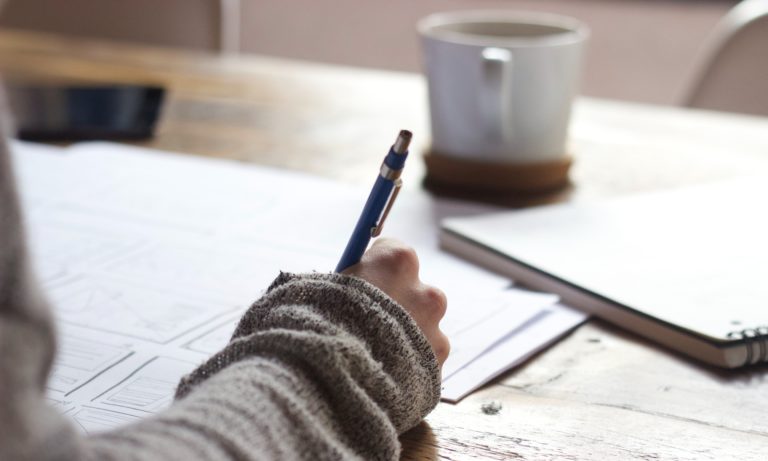 an-edmonton-homeowner-wearing-a-sweater-and-drinking-coffe-while-planning-a-home-renovation