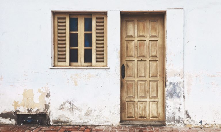 a-wooden-door-on-a-older-white-edmonton-home