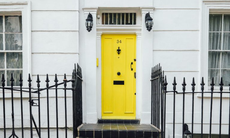 a-yellow-door-raising-the-curb-appeal-on-a-white-house