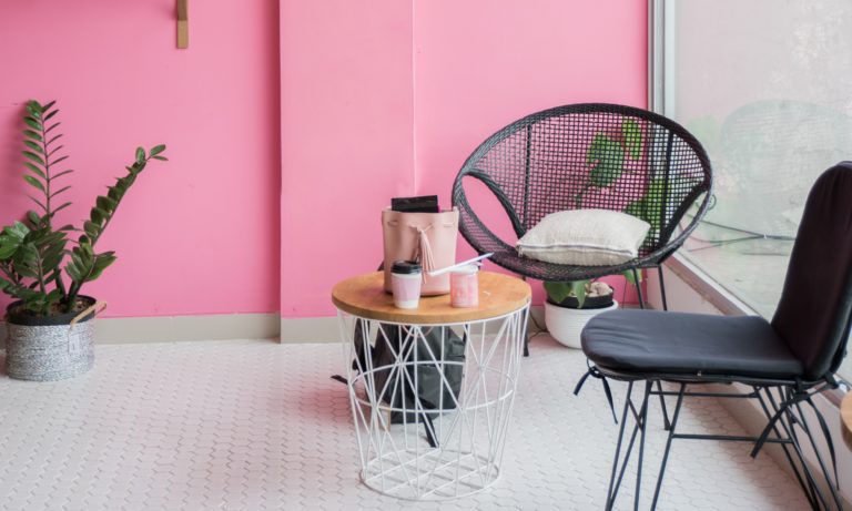 chair-sitting-in-front-of-a-pink-home-feature-wall