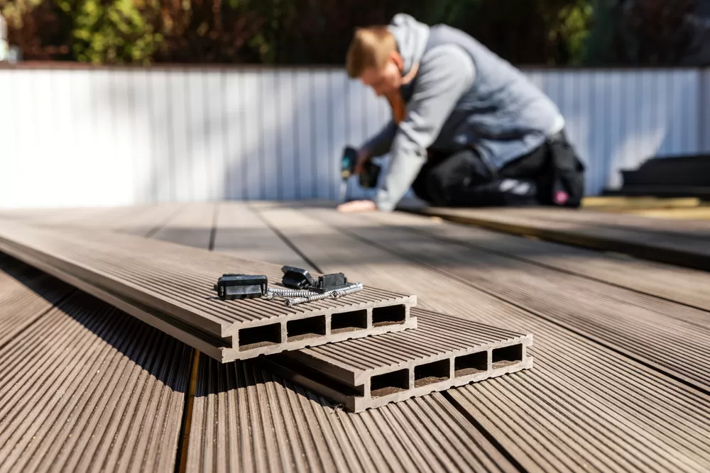 worker installing wood plastic composite decking boards