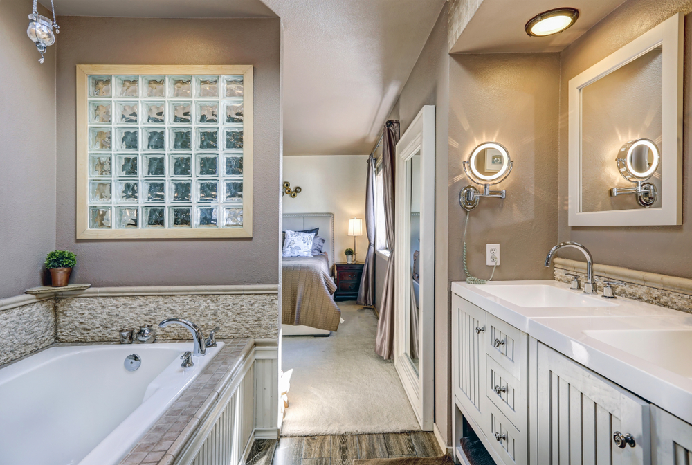 white and cream ensuite bathroom with 2 sinks and white bathtub