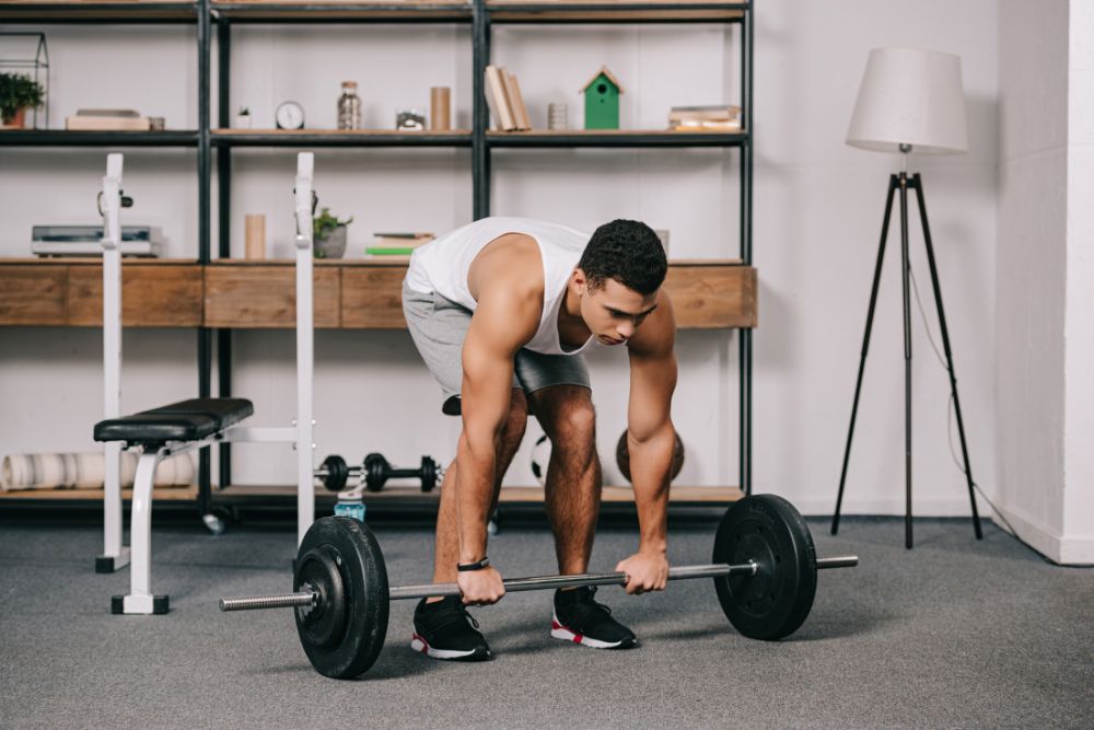 man lifts weights in basement